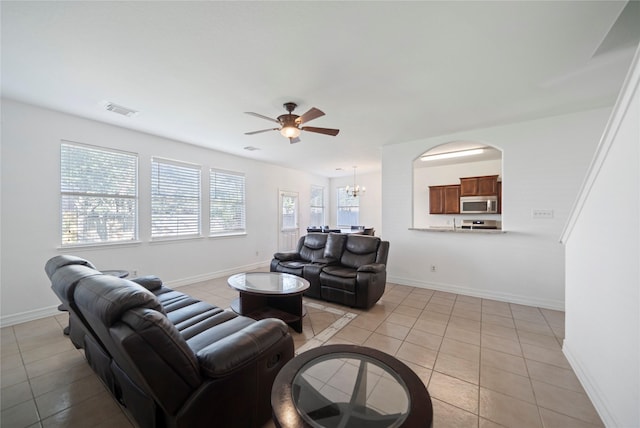 21355 Bella Mountain Dr, Spring, TX 77379 - living area featuring ceiling fan with notable chandelier, light tile patterned flooring, baseboards, and visible vents