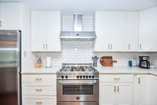 5902 Hummingbird St, Houston, TX 77096 - kitchen featuring appliances with stainless steel finishes, wall chimney range hood, light countertops, decorative backsplash, and white cabinetry