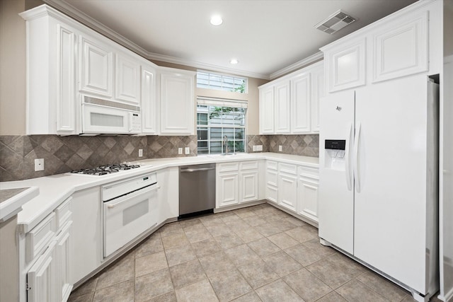 4422 Castle Court Pl, Houston, TX 77006 - kitchen with white appliances, tasteful backsplash, white cabinets, light countertops, and recessed lighting