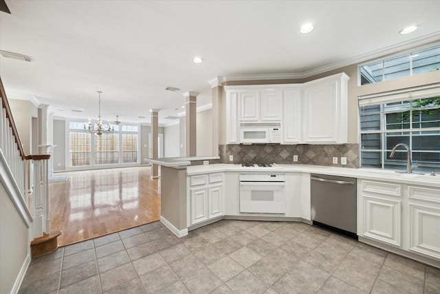 4422 Castle Court Pl, Houston, TX 77006 - kitchen featuring white appliances, ornamental molding, decorative columns, light countertops, and a peninsula