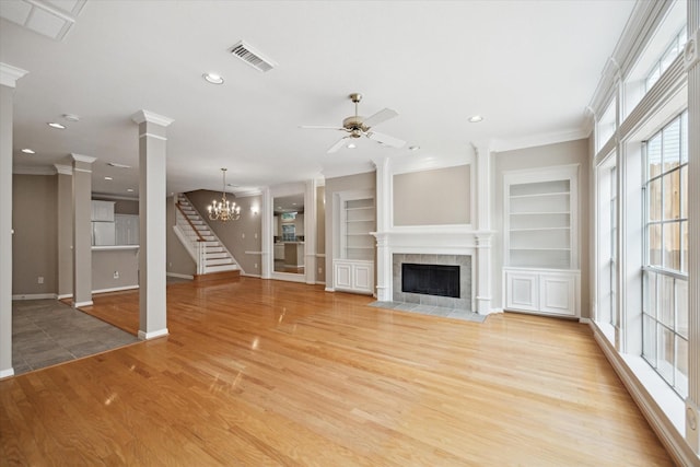 4422 Castle Court Pl, Houston, TX 77006 - unfurnished living room featuring ornate columns, crown molding, light wood finished floors, a ceiling fan, and a fireplace