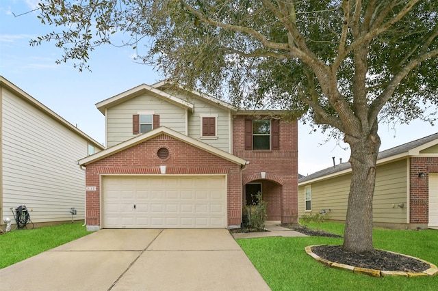 traditional-style home featuring an attached garage, driveway, a front yard, and brick siding