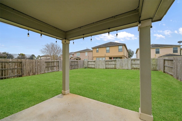 view of yard featuring a patio area, a fenced backyard, and a residential view
