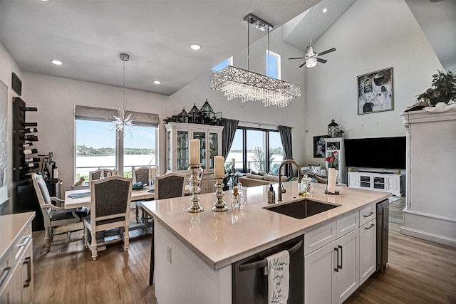 kitchen featuring dishwashing machine, open floor plan, dark wood-style floors, and a sink