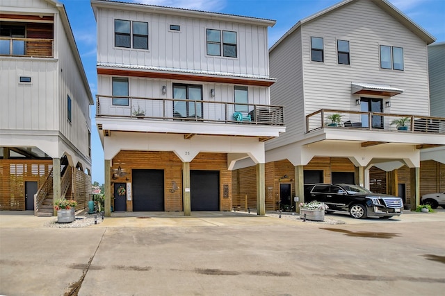 view of front of home with a carport, board and batten siding, a garage, and driveway