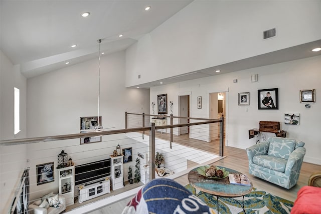 living area with high vaulted ceiling, recessed lighting, visible vents, and wood finished floors