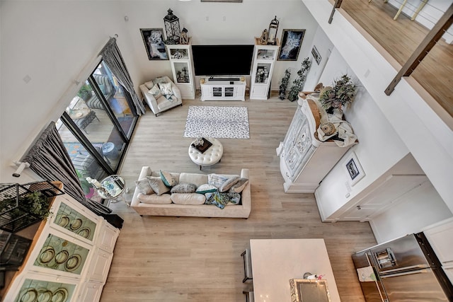 living area with a high ceiling and wood finished floors