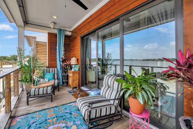 balcony featuring a water view and a ceiling fan