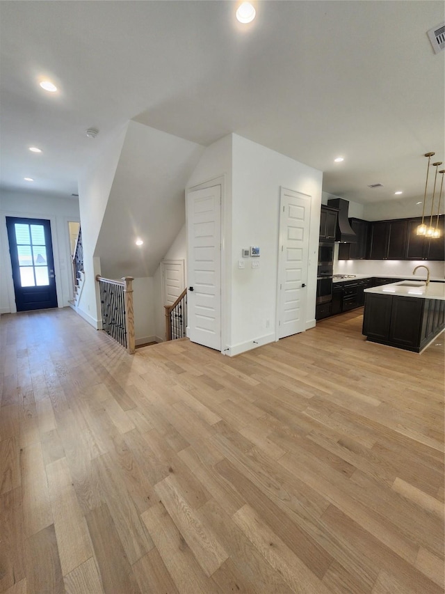 409 Forest Reserve Pl, Houston, TX 77079 - unfurnished living room with a sink, light wood-style floors, baseboards, and recessed lighting