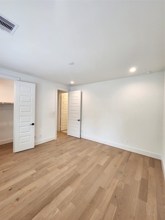 409 Forest Reserve Pl, Houston, TX 77079 - unfurnished bedroom featuring light wood-type flooring, a walk in closet, baseboards, recessed lighting, and a closet