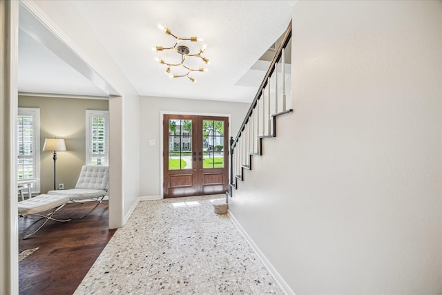 foyer with french doors, baseboards, an inviting chandelier, and stairs