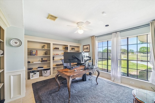 tiled home office featuring a ceiling fan and visible vents