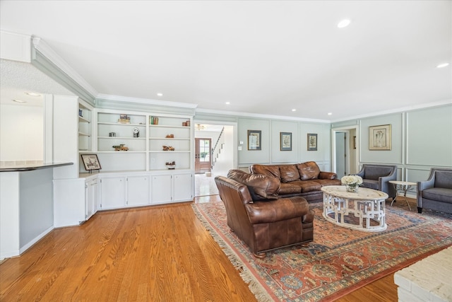 living area with stairway, recessed lighting, ornamental molding, and light wood-type flooring
