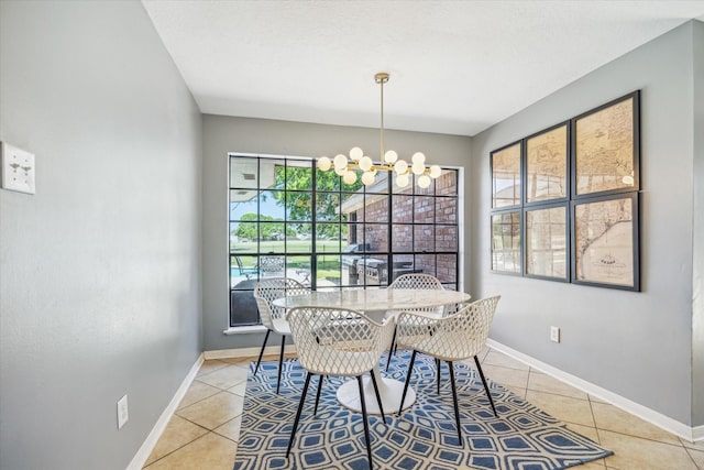 dining area featuring light tile patterned floors, baseboards, and an inviting chandelier