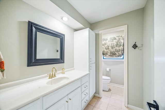 bathroom with tile patterned flooring, toilet, vanity, and baseboards