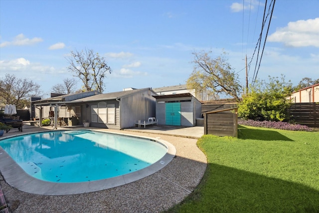 outdoor pool featuring a patio area, a yard, and fence