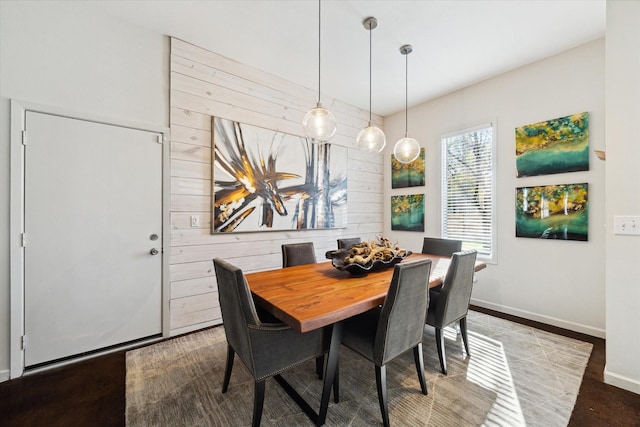 dining area with baseboards and wood finished floors