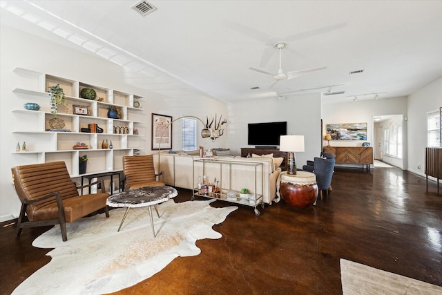 living area featuring rail lighting, visible vents, concrete flooring, and ceiling fan