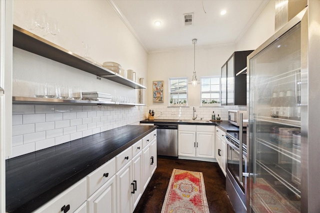 kitchen featuring tasteful backsplash, dark countertops, visible vents, appliances with stainless steel finishes, and a sink