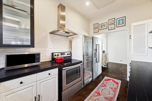 kitchen featuring crown molding, dark countertops, decorative backsplash, stainless steel appliances, and ventilation hood