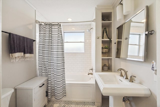 bathroom featuring a sink, toilet, and shower / bath combo with shower curtain