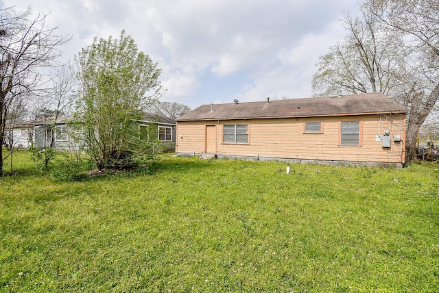 back of property featuring a yard and fence