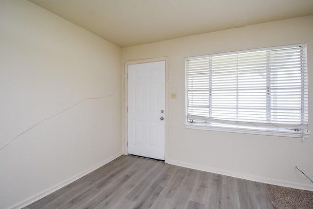 empty room featuring baseboards and light wood-type flooring