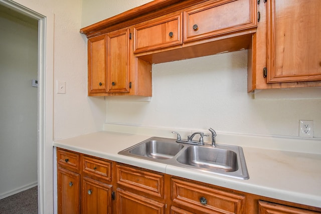 kitchen with a sink, brown cabinetry, and light countertops