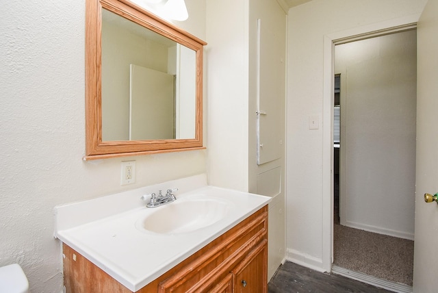 bathroom featuring vanity, baseboards, and toilet