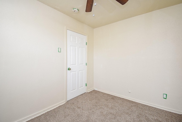 carpeted spare room with ceiling fan and baseboards