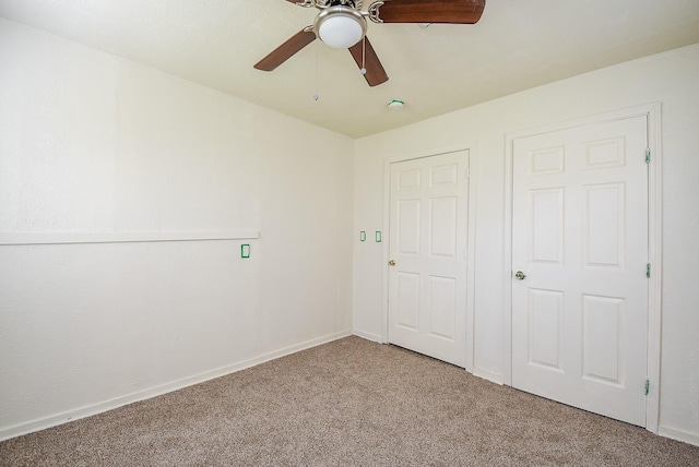unfurnished bedroom featuring baseboards, a ceiling fan, and carpet