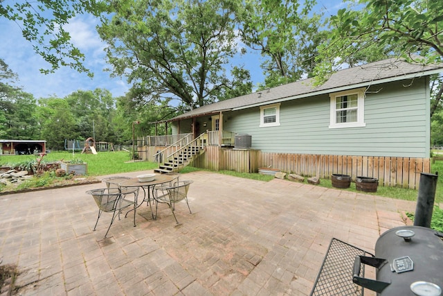 8335 Jernigan Rd, Conroe, TX 77306 - view of patio with central air condition unit, outdoor dining space, and a playground