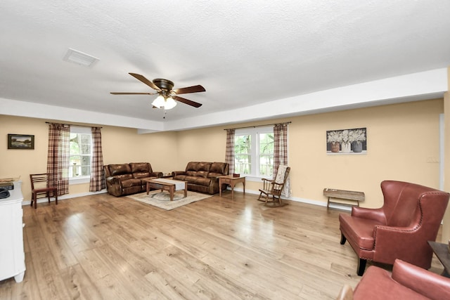 8335 Jernigan Rd, Conroe, TX 77306 - living room with ceiling fan, visible vents, baseboards, and light wood-type flooring