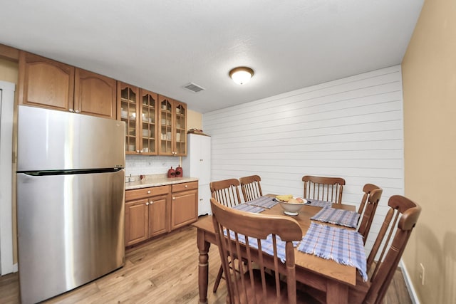 8335 Jernigan Rd, Conroe, TX 77306 - dining space featuring wood walls, visible vents, and light wood finished floors