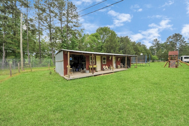 8335 Jernigan Rd, Conroe, TX 77306 - rear view of property featuring a trampoline, a wooden deck, fence, a playground, and a yard