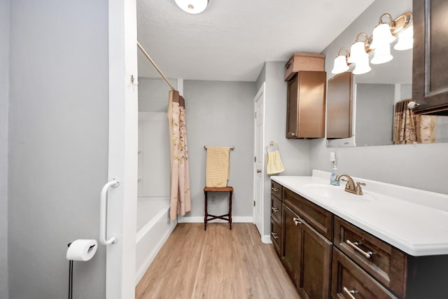 8335 Jernigan Rd, Conroe, TX 77306 - bathroom featuring baseboards, shower / bathtub combination with curtain, wood finished floors, and vanity