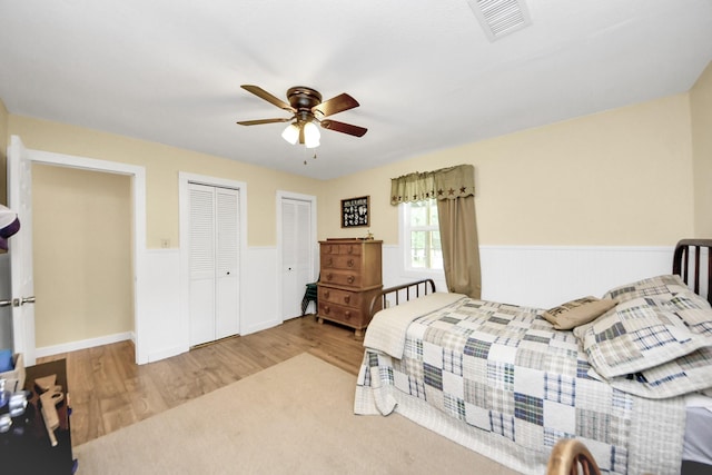 8335 Jernigan Rd, Conroe, TX 77306 - bedroom with visible vents, a ceiling fan, wood finished floors, and a wainscoted wall