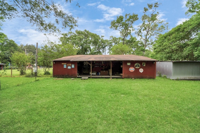 8335 Jernigan Rd, Conroe, TX 77306 - rear view of house with a yard, an outbuilding, and an outdoor structure