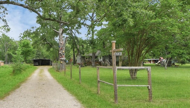 8335 Jernigan Rd, Conroe, TX 77306 - surrounding community with a yard, driveway, and a detached carport