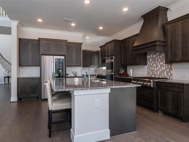 19103 Timpson Dr, Cypress, TX 77433 - kitchen with stainless steel appliances, premium range hood, a sink, dark brown cabinetry, and recessed lighting