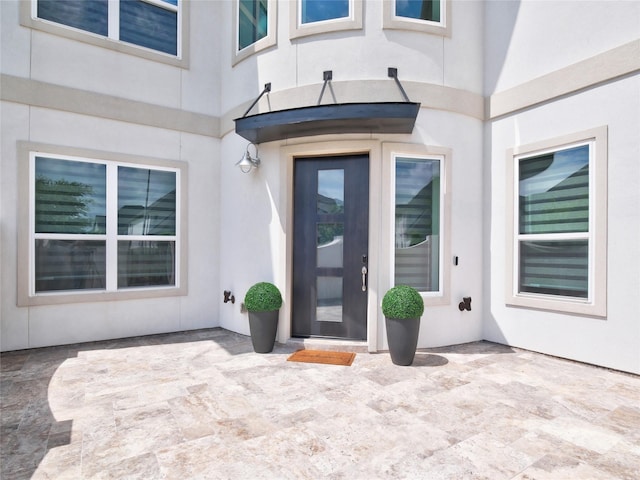 19103 Timpson Dr, Cypress, TX 77433 - view of exterior entry featuring a patio area and stucco siding