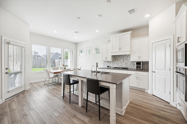 29035 Nectar Island Ln, Katy, TX 77494 - kitchen featuring a sink, stainless steel appliances, light wood-style flooring, a breakfast bar area, and recessed lighting
