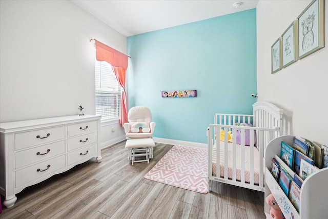 29035 Nectar Island Ln, Katy, TX 77494 - bedroom with a crib, wood finished floors, and baseboards