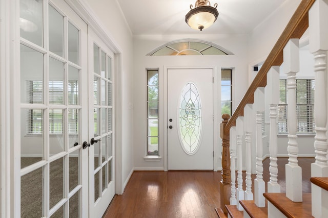 foyer featuring french doors, baseboards, hardwood / wood-style floors, and a healthy amount of sunlight