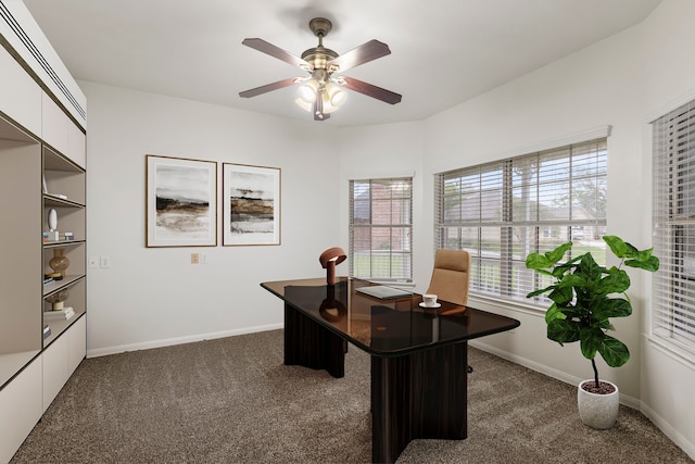 office with dark carpet, ceiling fan, and baseboards