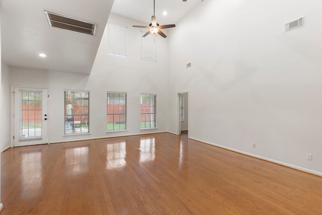 unfurnished living room with visible vents, ceiling fan, wood finished floors, and baseboards