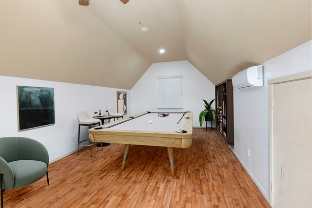 game room featuring pool table, light wood-type flooring, a wall unit AC, vaulted ceiling, and baseboards