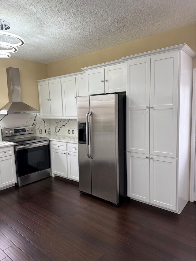 kitchen with backsplash, wall chimney range hood, white cabinetry, appliances with stainless steel finishes, and dark wood-style floors
