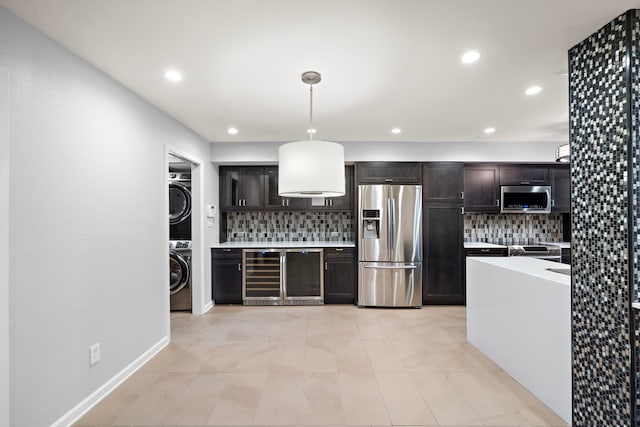 8954 Chatsworth Dr, Houston, TX 77024 - kitchen featuring appliances with stainless steel finishes, beverage cooler, estacked washer and dryer, tasteful backsplash, and recessed lighting