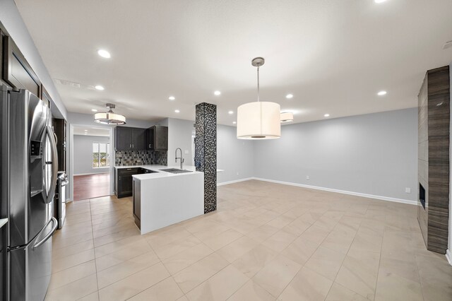 8954 Chatsworth Dr, Houston, TX 77024 - kitchen featuring stainless steel fridge with ice dispenser, a sink, open floor plan, recessed lighting, and light countertops